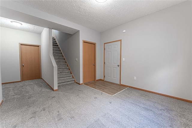 26805 Stephanie Ln, Laquey, MO 65534 - unfurnished room featuring carpet flooring, stairway, baseboards, and a textured ceiling