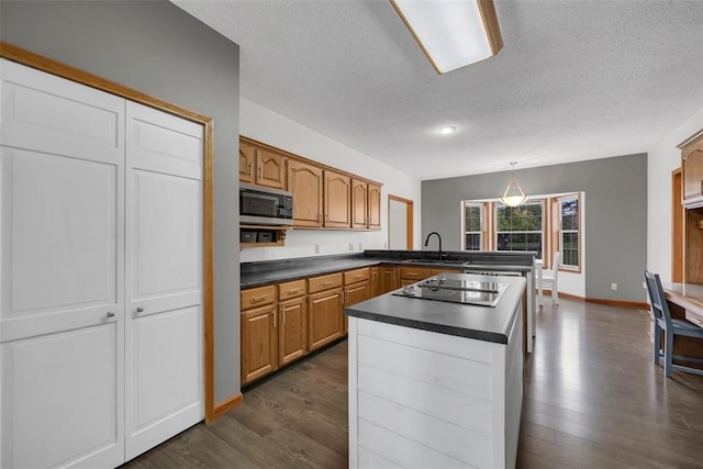 3 Jura Ct, Ofallon, MO 63368 - kitchen featuring stainless steel microwave, a textured ceiling, black electric stovetop, dark countertops, and a peninsula