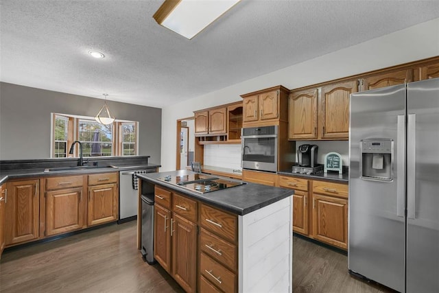 3 Jura Ct, Ofallon, MO 63368 - kitchen with appliances with stainless steel finishes, a sink, a textured ceiling, dark countertops, and dark wood-type flooring