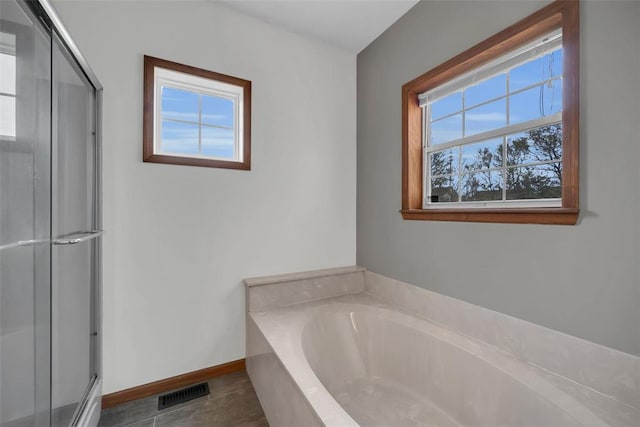 3 Jura Ct, Ofallon, MO 63368 - bathroom with healthy amount of natural light, a shower stall, a garden tub, and baseboards