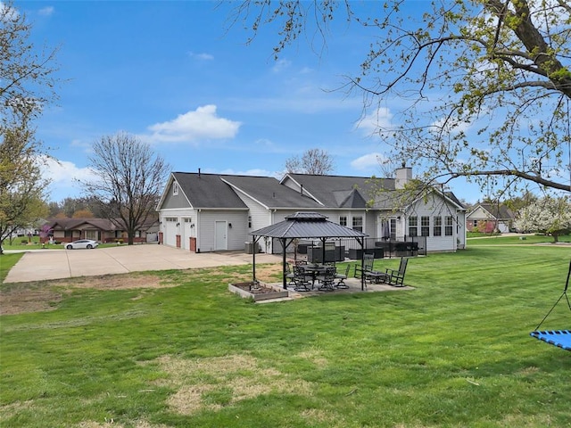3 Jura Ct, Ofallon, MO 63368 - back of house featuring a gazebo, a chimney, a yard, concrete driveway, and an attached garage