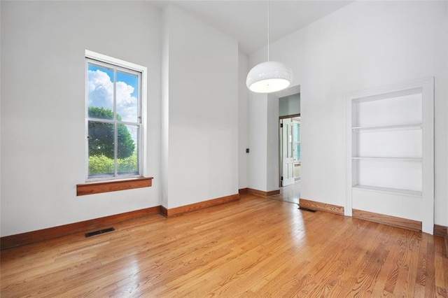 1225 Mackay Pl, Saint Louis, MO 63104 - unfurnished room with plenty of natural light, high vaulted ceiling, light wood-style flooring, and baseboards
