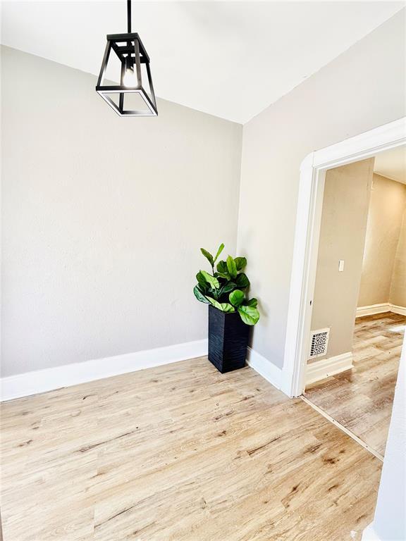 unfurnished room with wood finished floors and baseboards