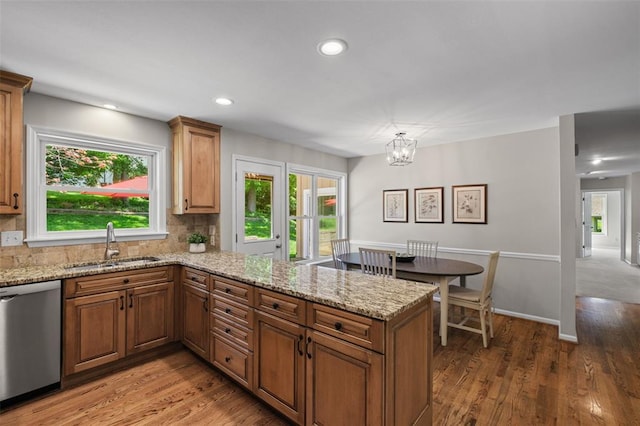 1807 Brookcreek Ln, Kirkwood, MO 63122 - kitchen featuring stainless steel dishwasher, a sink, a peninsula, wood finished floors, and a chandelier