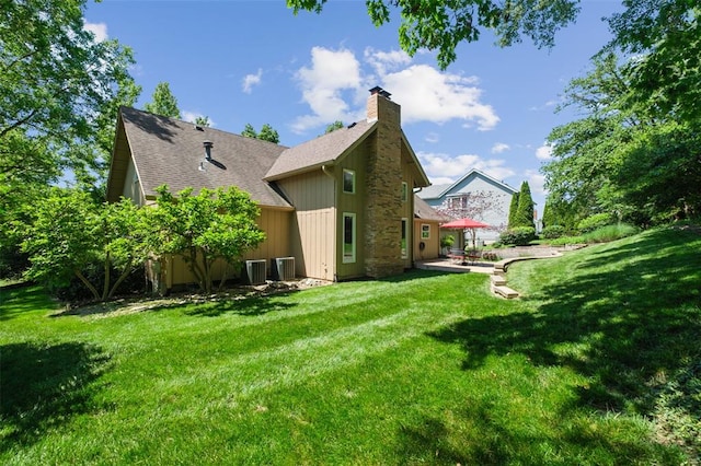 1807 Brookcreek Ln, Kirkwood, MO 63122 - back of property with a chimney, a yard, central AC, and roof with shingles
