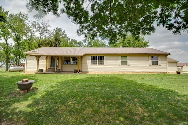27467 Spruce Rd, Greenfield, IL 62044 - rear view of house with covered porch, a lawn, metal roof, and an outdoor fire pit