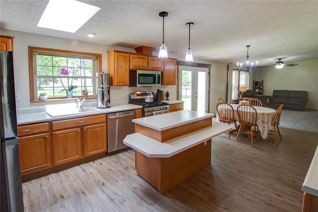 27467 Spruce Rd, Greenfield, IL 62044 - kitchen with stainless steel appliances, a sink, a textured ceiling, a center island, and light countertops