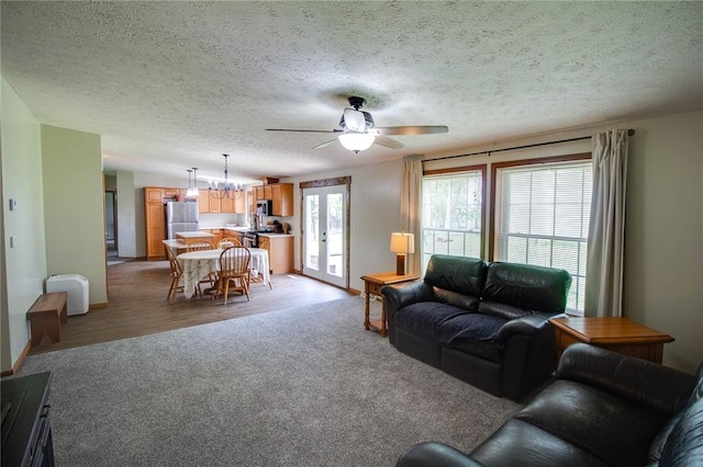 27467 Spruce Rd, Greenfield, IL 62044 - living room featuring light carpet, a ceiling fan, a textured ceiling, baseboards, and a chandelier