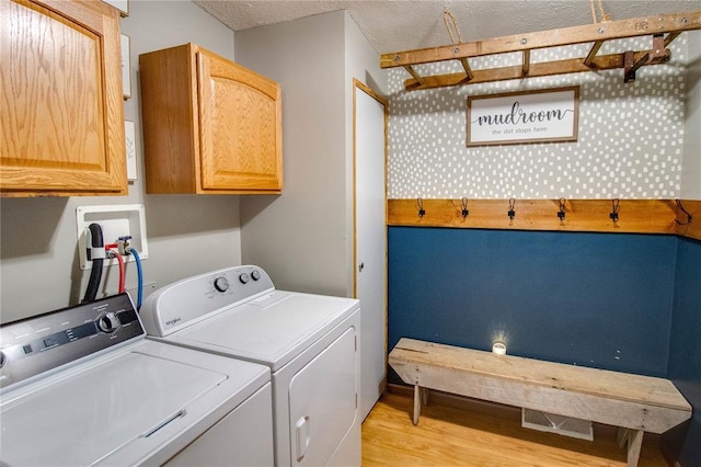 27467 Spruce Rd, Greenfield, IL 62044 - washroom featuring washer and dryer, light wood-type flooring, cabinet space, and a textured ceiling