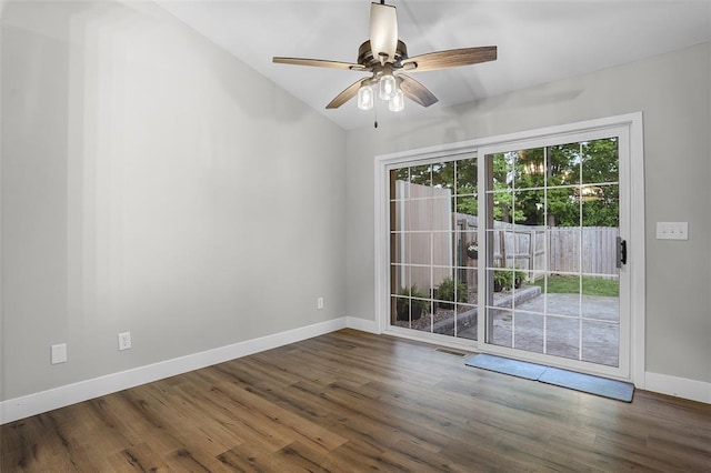 empty room featuring vaulted ceiling, baseboards, a ceiling fan, and wood finished floors