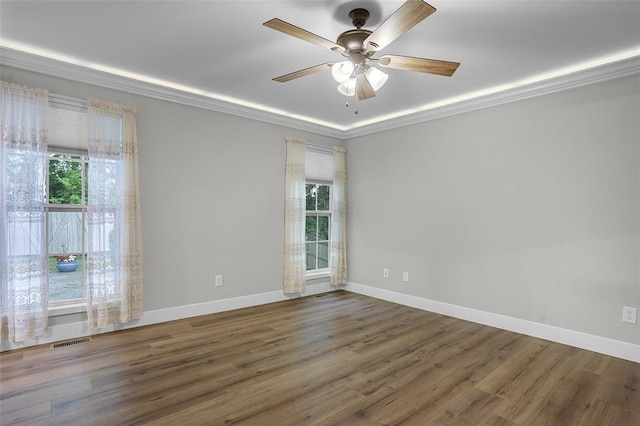 spare room featuring plenty of natural light, ornamental molding, and wood finished floors