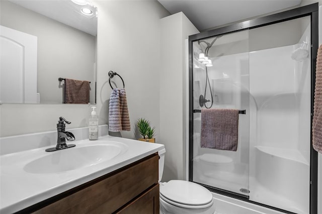bathroom with a stall shower, toilet, and vanity
