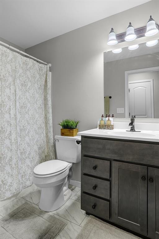 bathroom featuring marble finish floors, toilet, and vanity