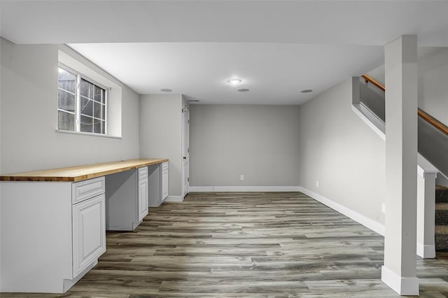 below grade area with wood finished floors, stairs, baseboards, and recessed lighting