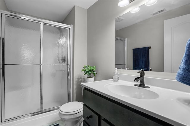 bathroom featuring a stall shower, vanity, and toilet