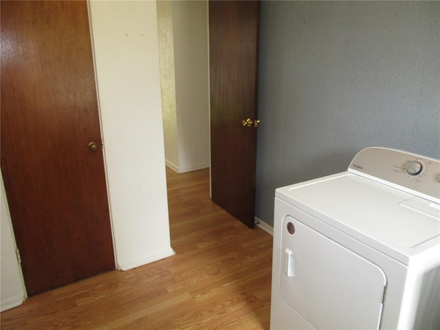 laundry area with washer / clothes dryer, light wood-style floors, and baseboards