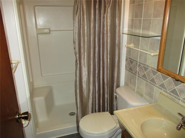 full bathroom featuring a stall shower, tasteful backsplash, toilet, and vanity