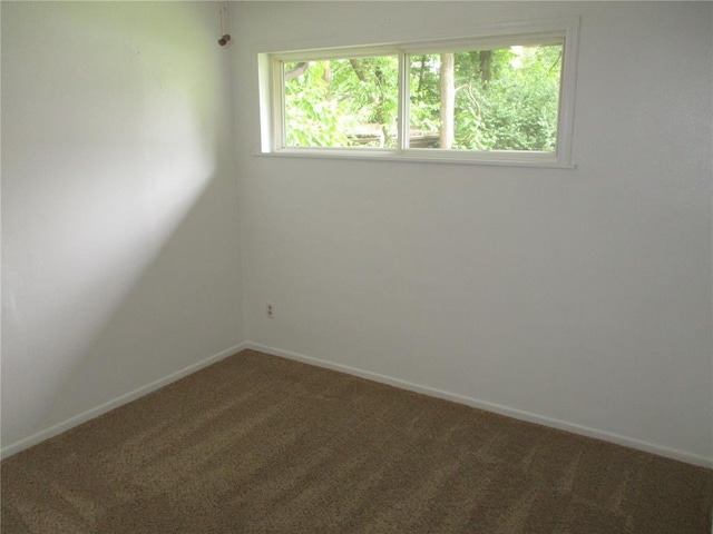 unfurnished room with carpet and baseboards
