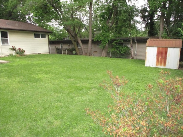 view of grassy yard with a storage shed and an outdoor structure