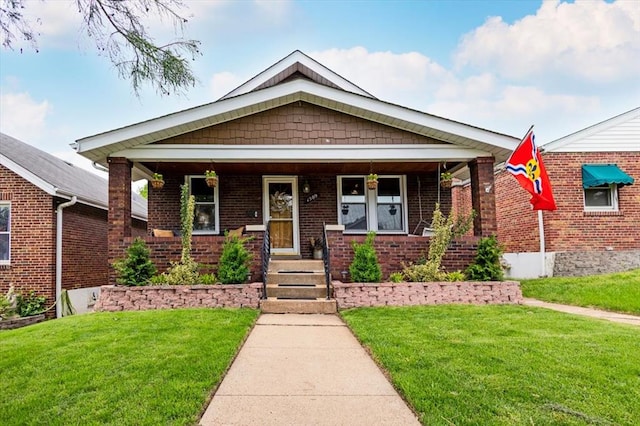 view of front of home featuring a front lawn, a porch, and brick siding