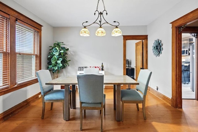 dining space with baseboards and wood finished floors