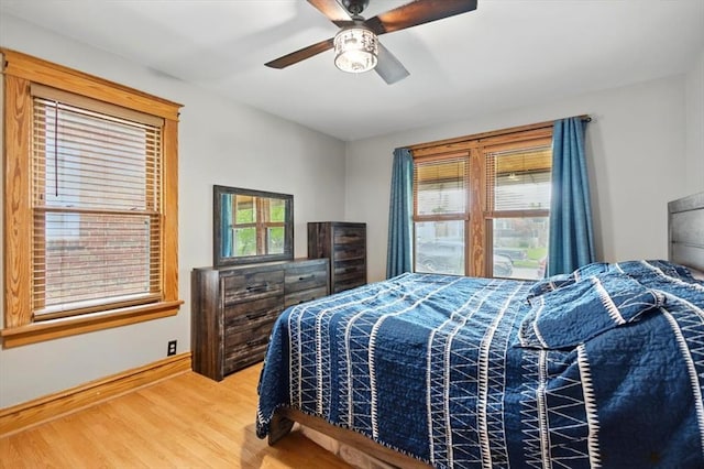 bedroom with wood finished floors, a ceiling fan, and baseboards