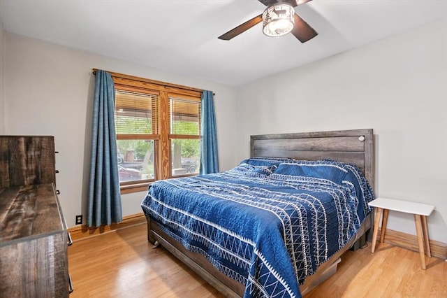 bedroom featuring wood finished floors, baseboards, and ceiling fan