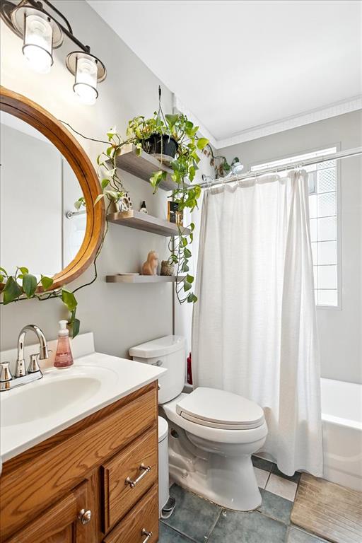 full bath with toilet, vanity, tile patterned flooring, and shower / bath combination with curtain