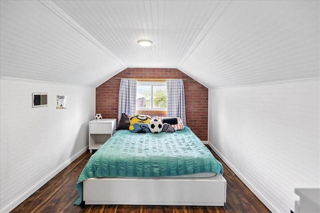 bedroom with brick wall, lofted ceiling, baseboards, and wood finished floors