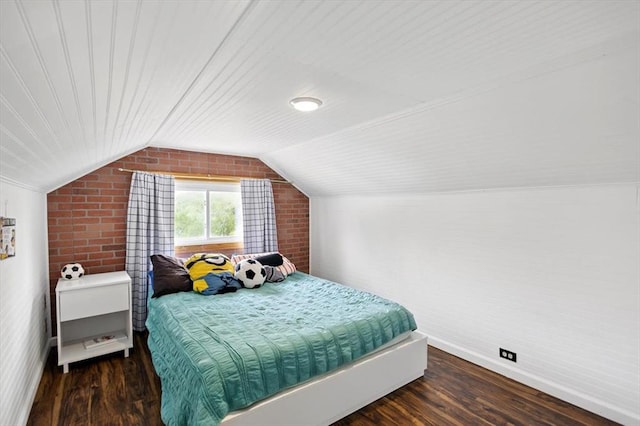 bedroom featuring brick wall, wood finished floors, vaulted ceiling, and baseboards