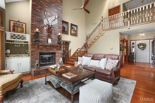1553 Ridge Rd, Wildwood, MO 63021 - living room featuring a high ceiling, wood finished floors, stairs, a ceiling fan, and a fireplace