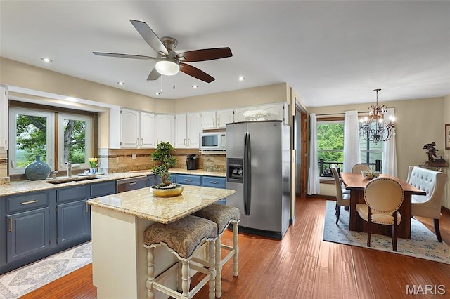 1553 Ridge Rd, Wildwood, MO 63021 - kitchen featuring appliances with stainless steel finishes, white cabinetry, tasteful backsplash, a kitchen island, and ceiling fan