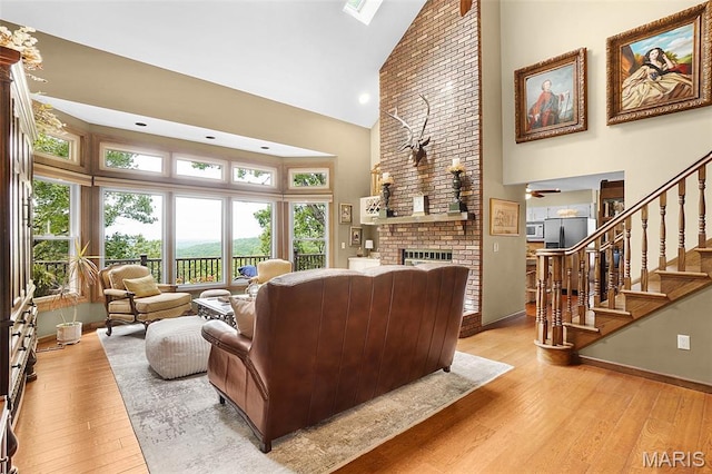 1553 Ridge Rd, Wildwood, MO 63021 - living room featuring high vaulted ceiling, light wood-type flooring, plenty of natural light, a fireplace, and stairs