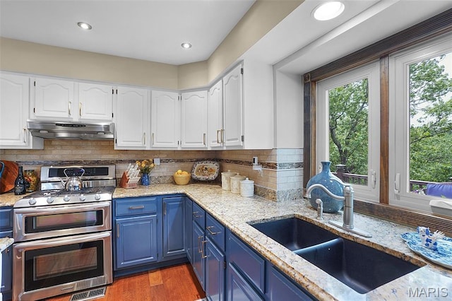 1553 Ridge Rd, Wildwood, MO 63021 - kitchen featuring double oven range, blue cabinets, under cabinet range hood, white cabinets, and recessed lighting
