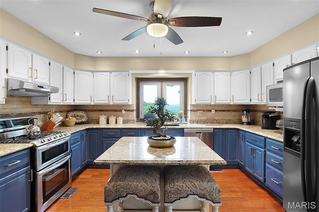 1553 Ridge Rd, Wildwood, MO 63021 - kitchen featuring stainless steel appliances, under cabinet range hood, blue cabinets, ceiling fan, and white cabinets