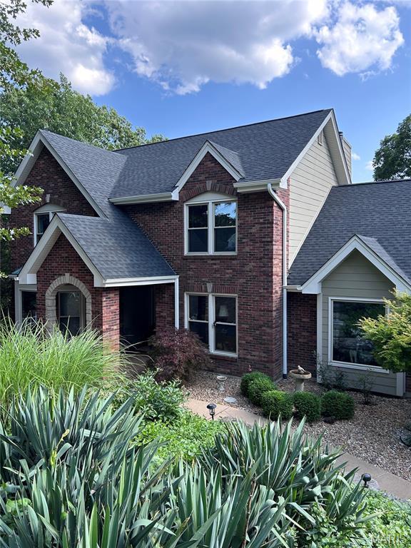 1553 Ridge Rd, Wildwood, MO 63021 - traditional-style house featuring roof with shingles, brick siding, and a chimney