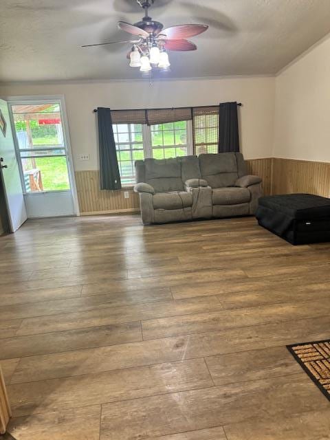 756 Eldon Dr, Bismarck, MO 63624 - living area featuring a wainscoted wall, a ceiling fan, hardwood / wood-style flooring, and wood walls