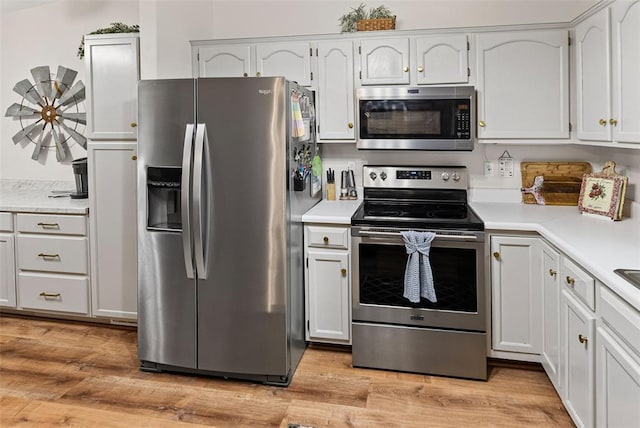 kitchen with stainless steel appliances, light countertops, and light wood-style floors