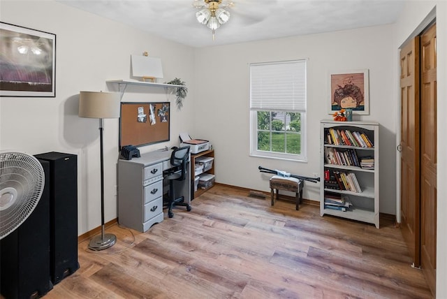 office space featuring a ceiling fan, wood finished floors, and baseboards