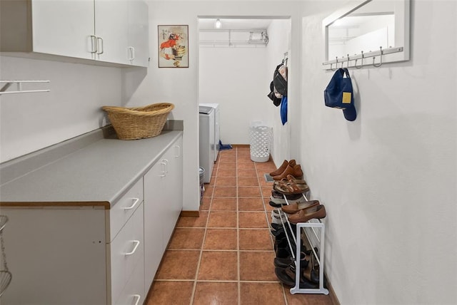 laundry area featuring cabinet space and tile patterned flooring