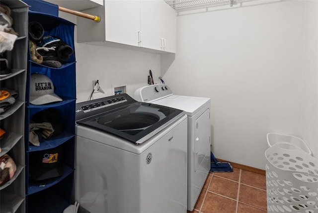 washroom featuring independent washer and dryer, cabinet space, tile patterned flooring, and baseboards