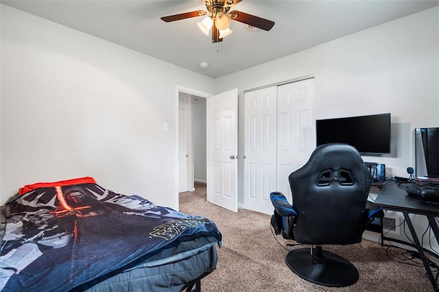 carpeted bedroom with an office area, a closet, ceiling fan, and baseboards
