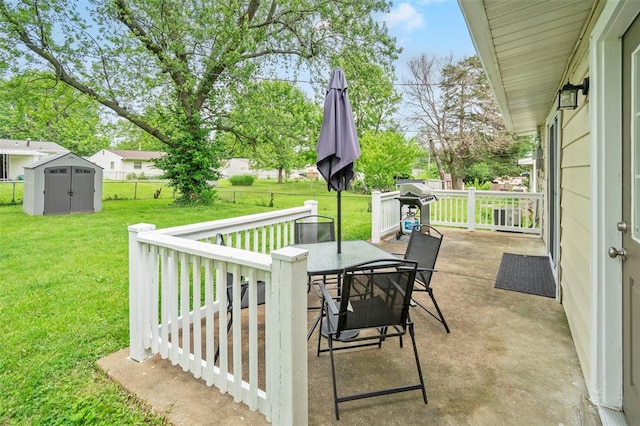 view of patio featuring a shed, outdoor dining area, area for grilling, an outbuilding, and a wooden deck