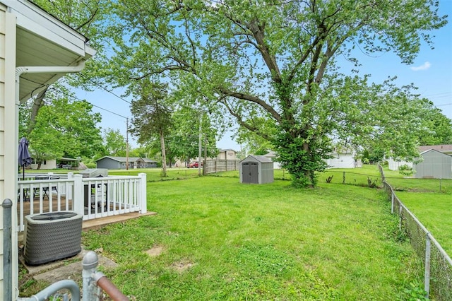 view of yard with a shed, an outbuilding, and central air condition unit