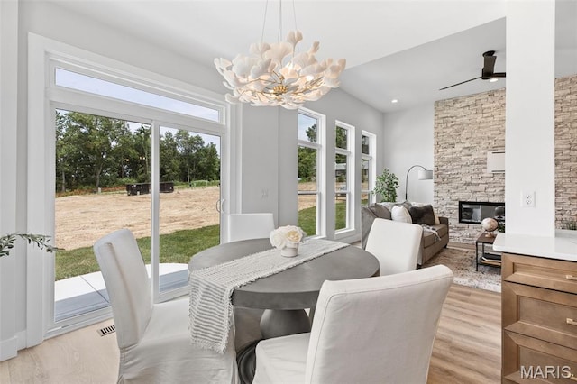 401 Rayburn Ave, Sunset Hills, MO 63127 - dining room with a chandelier, healthy amount of natural light, light wood finished floors, a stone fireplace, and recessed lighting