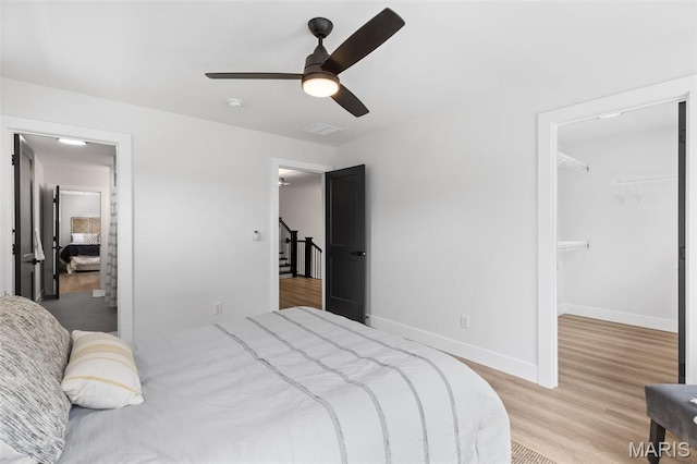 401 Rayburn Ave, Sunset Hills, MO 63127 - bedroom featuring light wood-style flooring, a walk in closet, baseboards, and a ceiling fan