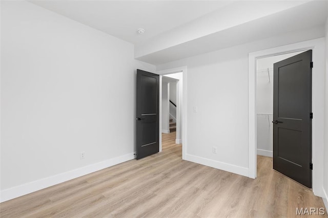 401 Rayburn Ave, Sunset Hills, MO 63127 - unfurnished bedroom with light wood-type flooring, a walk in closet, baseboards, and a closet