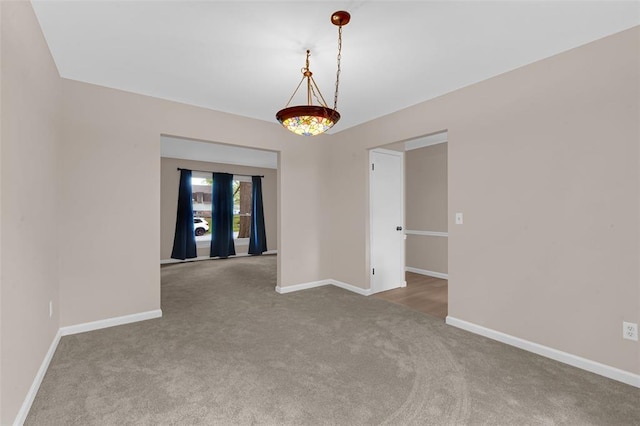 carpeted spare room with baseboards