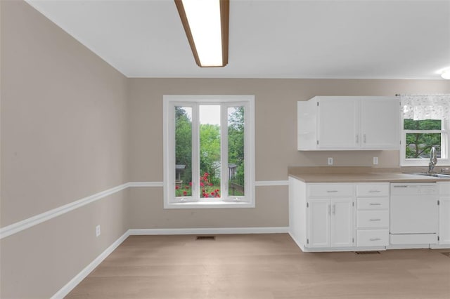 kitchen with dishwasher, plenty of natural light, and white cabinets