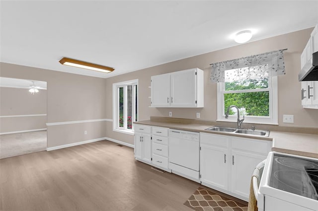 kitchen with a sink, white appliances, light wood finished floors, and white cabinets